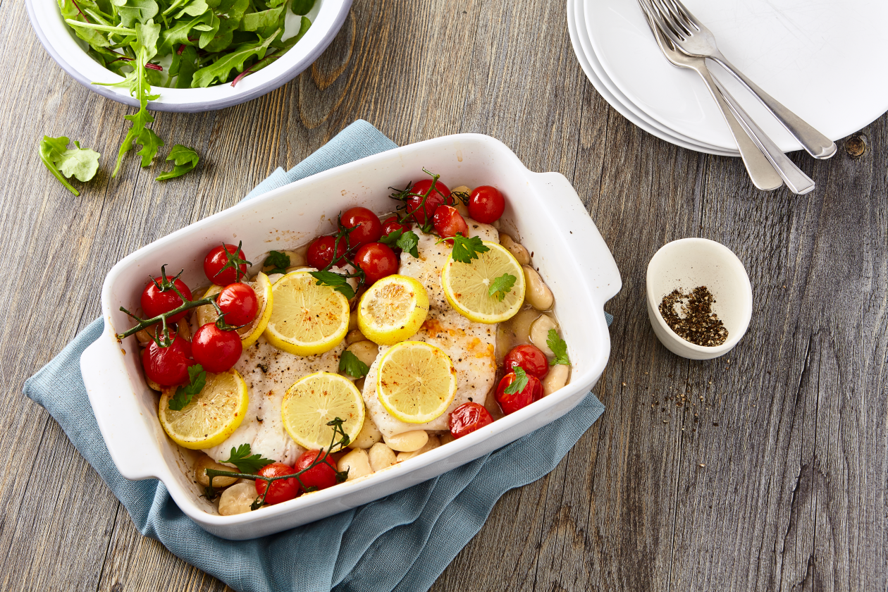 A photograph of Baked cod with butter beans and vine tomatoes