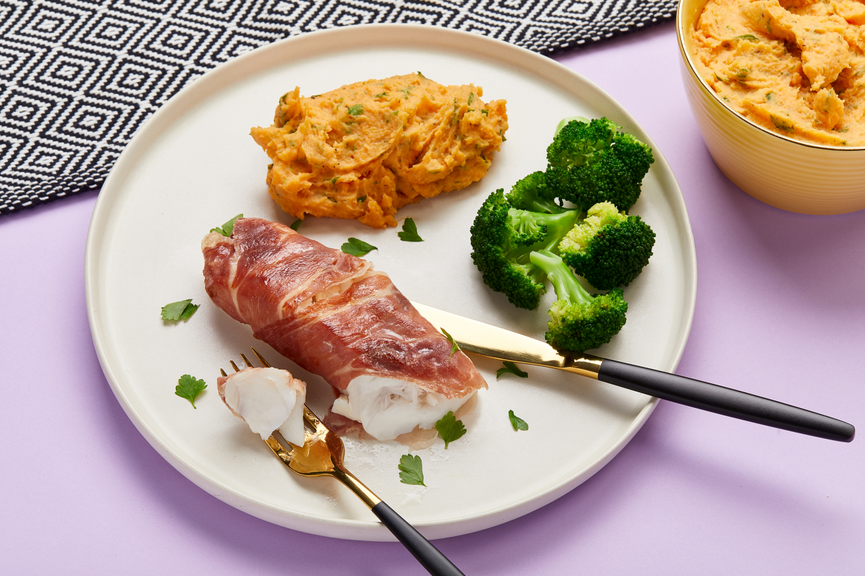 A photograph of Cod with parma ham and sweet potato mash